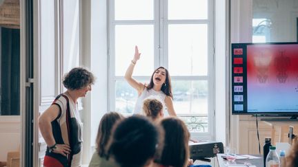 La coach vocale (le bras en l'air) prodigue ses conseils &agrave; une classe d'&eacute;l&egrave;ves. (ELENA HURSTEL)